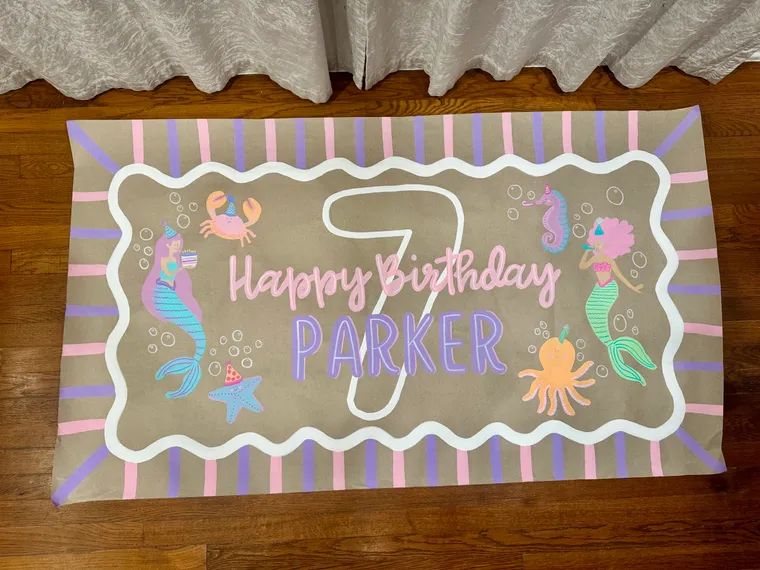 Hand-painted mermaid birthday banner reading Happy Birthday Parker on kraft paper